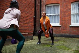 Picture of two women working out in their courtyard